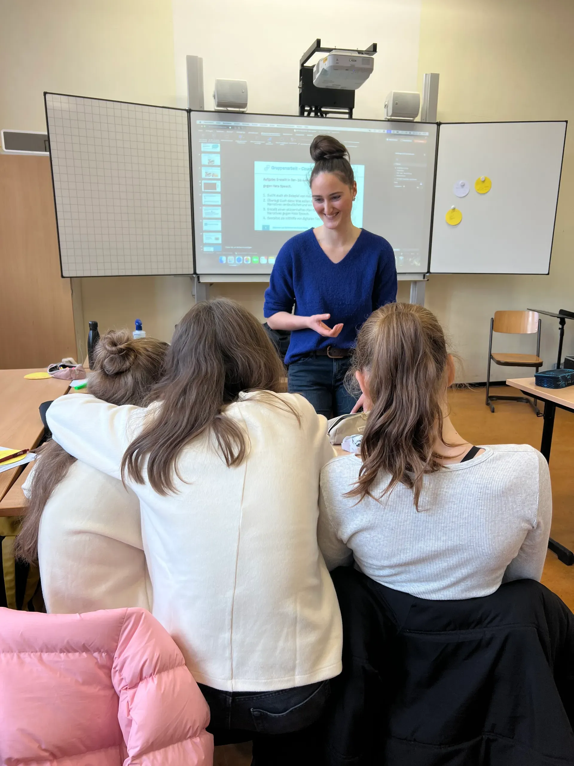 Eine Übungsleitung steht vor drei jungen Schülerinnen.